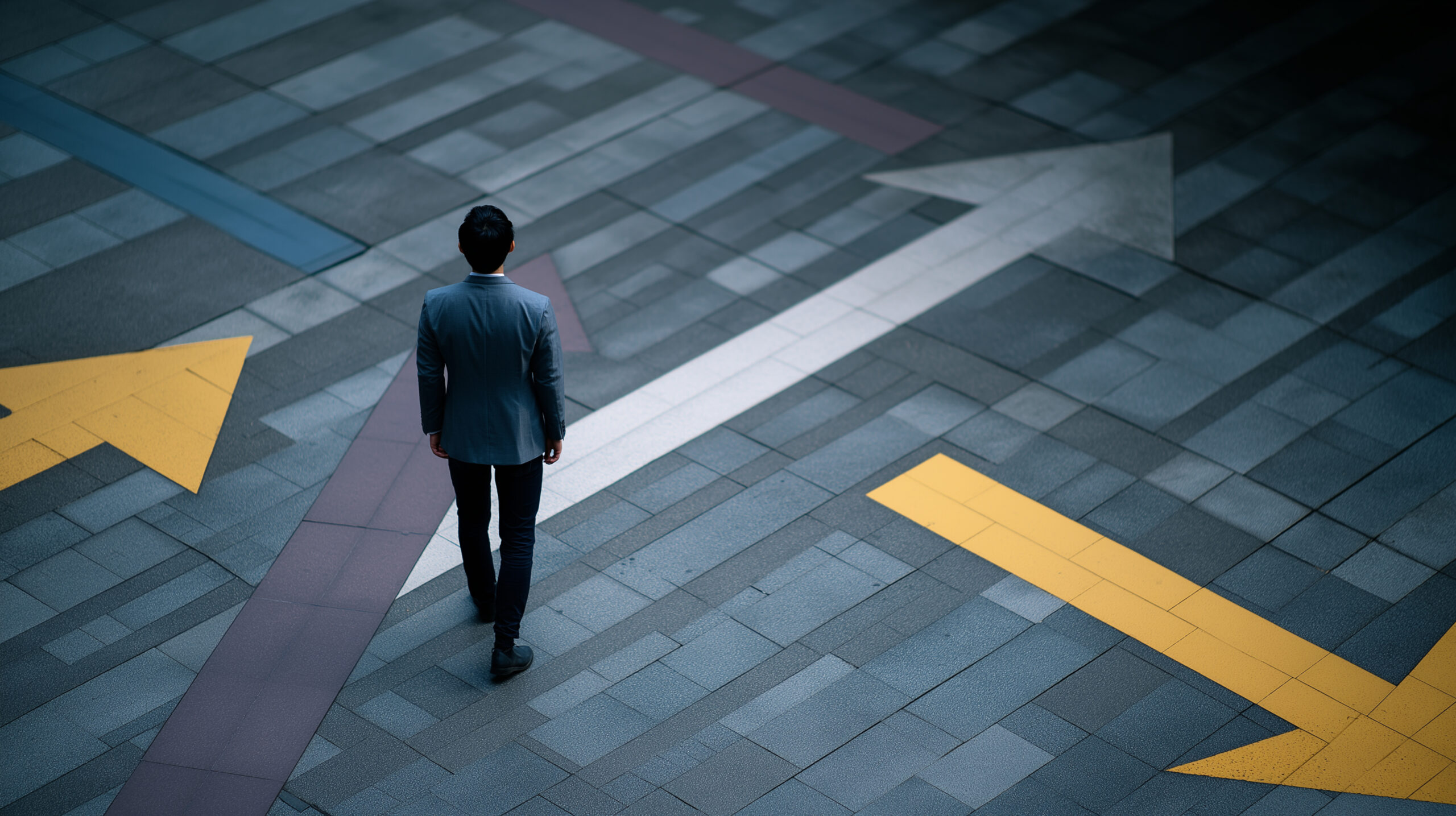 Man in a suit standing on pavement looking at the floor with many arrows pointing at different directions.